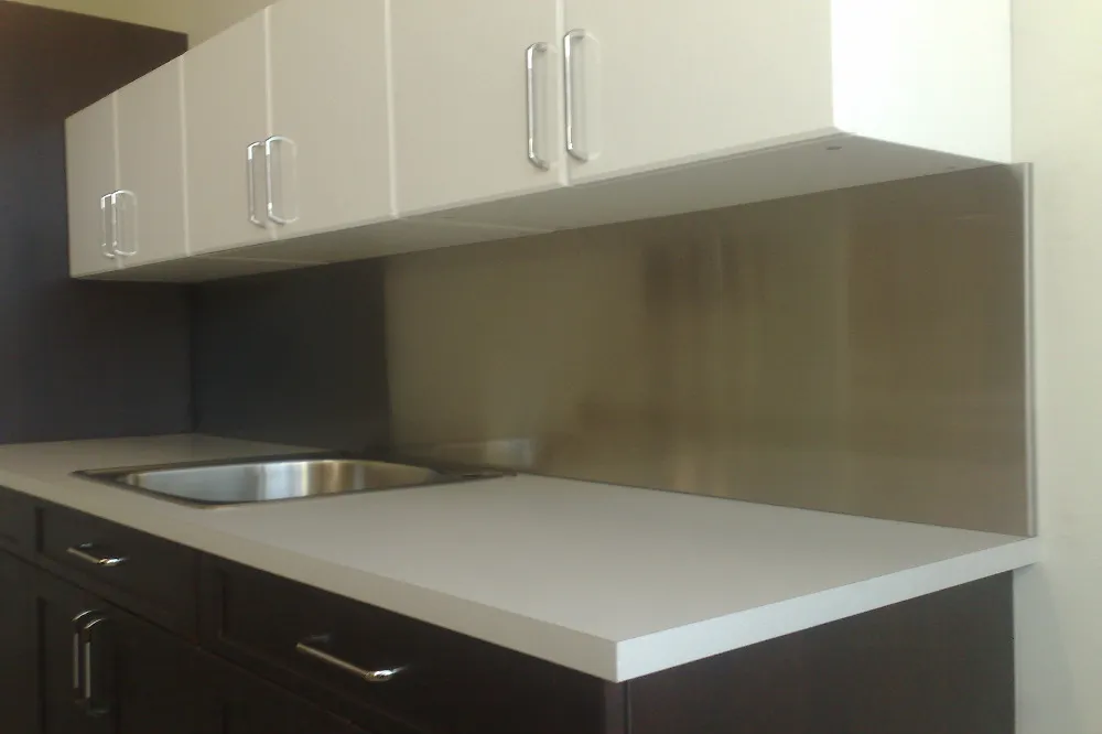 Full-height stainless backsplash, white kitchen